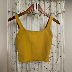 Never worn, one size fits all spandex workout top. Goldish/ mustard color